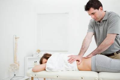 A Chiropractor Working on a Patient with Lower Back Pain
